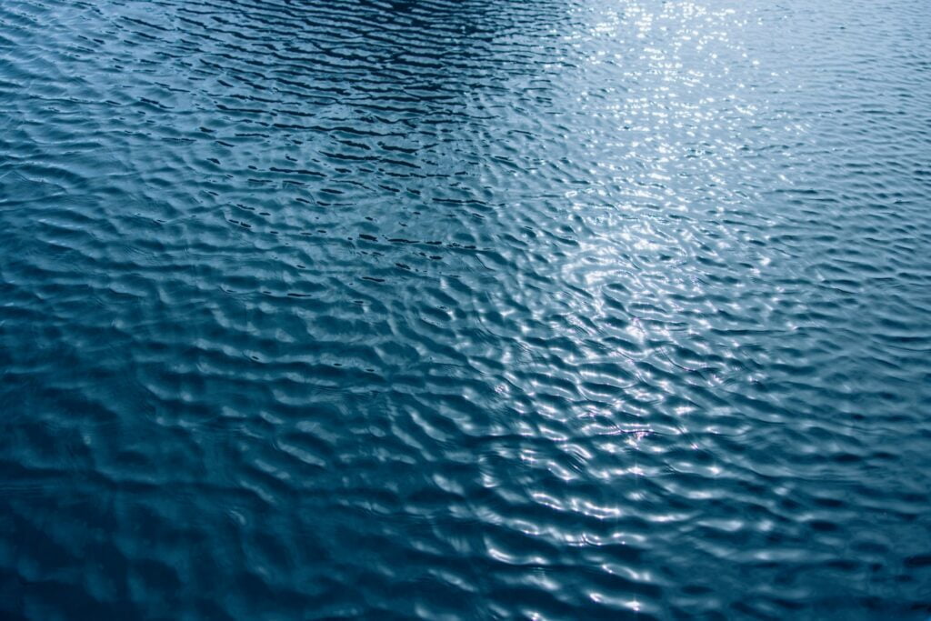 Wasser im Hafen Marina Plaue auf dessen Oberfläche sich Sonnenstrahlen spiegelt